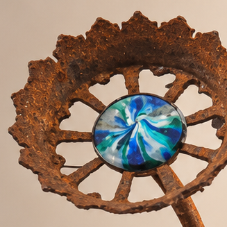 Ocean Iris Bloom, rusted steel gear flower with a blue and teal swirled glass center - detail