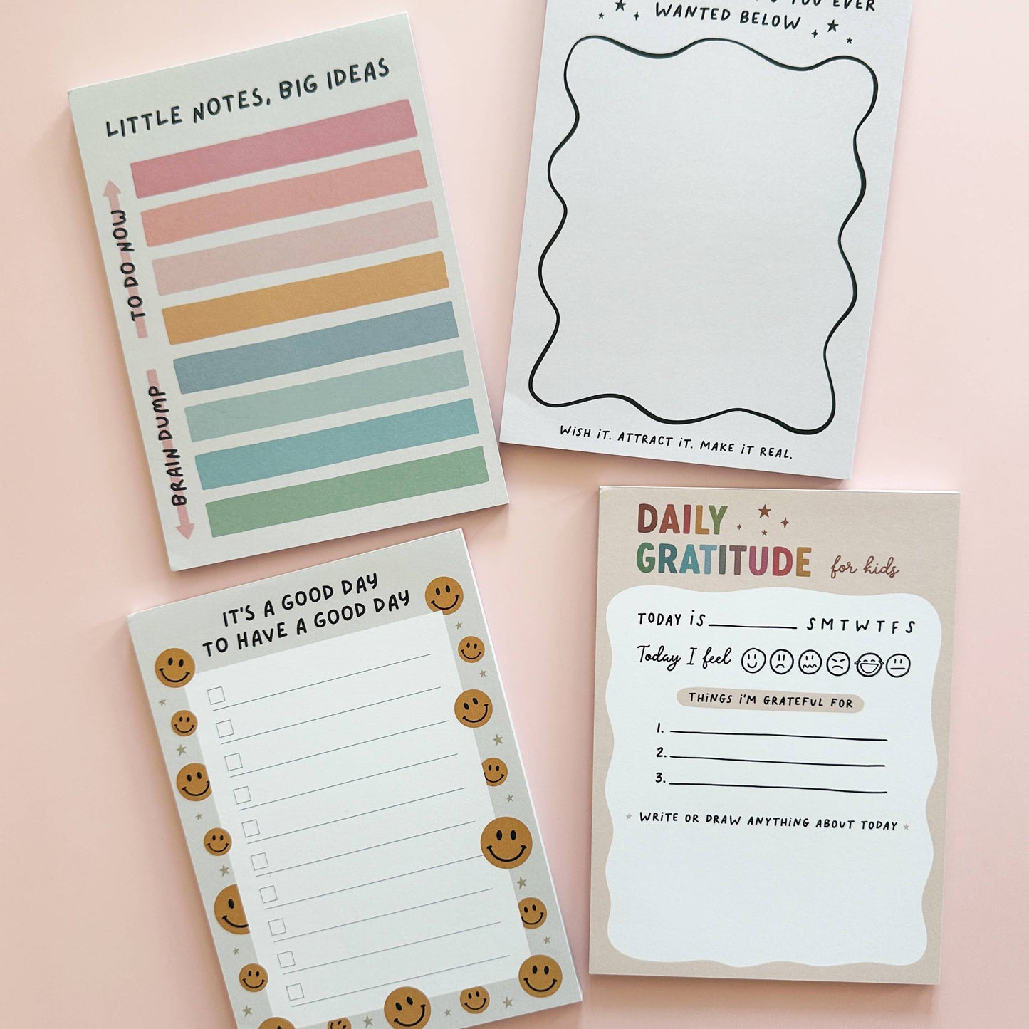 Four different notepads with various designs and text on a pink background