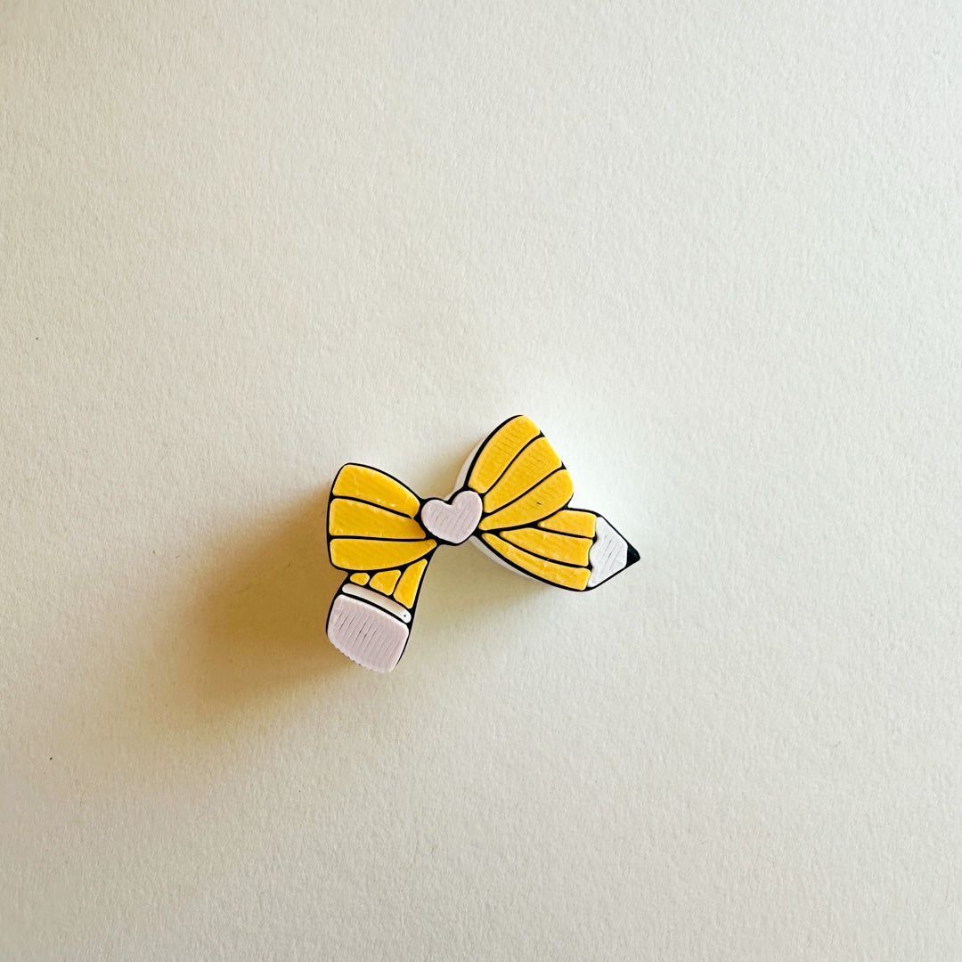 Yellow bow-shaped hair clip on a beige background